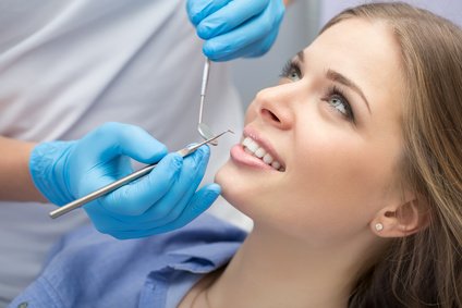 Nahaufnahme einer lächelnden Patientin während einer Zahnuntersuchung