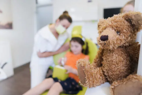 helferin_und_kind_teddy_im_vordergrund